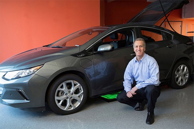 Alex Gruzen, CEO di WiTricity, con una Chevrolet Volt parcheggiata sopra al sistema per la ricarica wireless della batteria